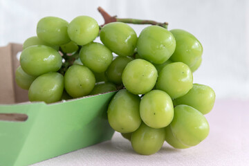 Ripe green korea grape fruit put in wooden bamboo basket  hand made cloth background.