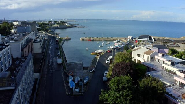 Bullock Harbour, Dalkey, Dublin, Ireland, September 2021. Drone slowly pushes forward over the harbour from the southeast towards the stone quay with Sandycove and D&uacute;n Laoghaire in the background.