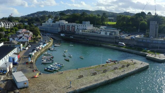Bullock Harbour, Dalkey, Dublin, Ireland, September 2021. Drone gradually orbits west while ascending up behind Bullock castle.