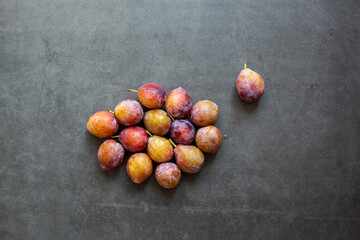 Ripe Plums prunes fruit on dark background.top view