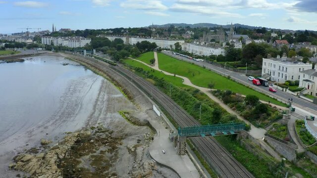Monkstown, Dublin, Ireland, September 2021. Drone gradually descends as a Dart train passes along the coastal railway with the view east towards D&uacute;n Laoghaire in the background.
