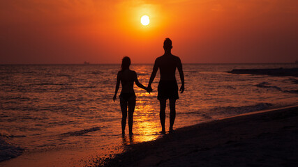 Fototapeta premium couple on the beach at sunset