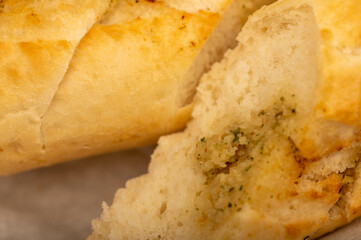 Baguette with garlic paste cut into pieces, close-up, selective focus.
