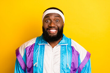 Photo of pretty funny dark skin guy dressed sport suit headband smiling isolated yellow color background