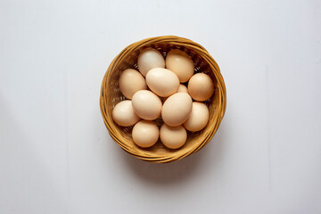 Fresh Chicken eggs in Bamboo basket on a white background.
