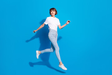 Photo of sweet adorable young lady wear white outfit smiling walking isolated blue color background