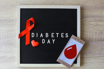 World Diabetes Day creative flat lay concept with red ribbon, blood symbol, drugs and syringe