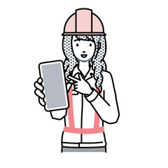 立ってスマートフォンを指差してこちらに向けて見せている工事現場の女性
