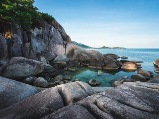 Hin Ta Hin Yai, Lamai Beach, Koh Samui Island, Thailand. Scenic view of stunning rock formation cliff, rocky bay with hidden small lagoon, blue water against blue sky. 