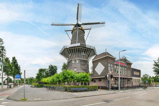 Old windmill and building facade against urban road