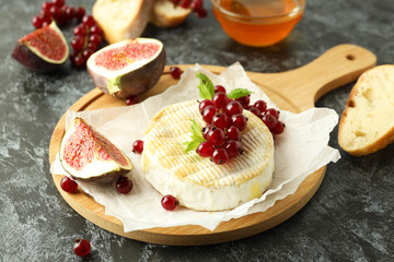 Concept of tasty food with grilled camembert on black smokey background