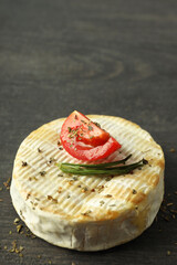 Tasty grilled camembert on dark wooden background