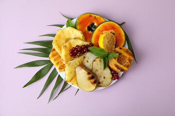 Concept of tasty food with grilled fruits on violet background