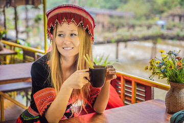 A female tourist dressed in the traditional dress of the inhabitants of the Vietnamese mountains,...