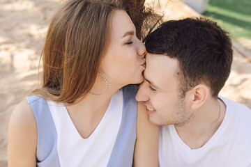 Young woman kisses her husband during their honeymoon. Recreation and tourism. Romantic relationships. Love and tenderness. Rest at the hotel. Honeymoon. Wonderful moments of life.