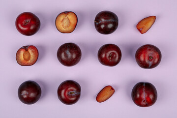Flat lay composition with plums on purple background