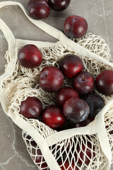 Concept of fruits with plums on gray textured table
