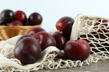 Concept of fruits with plums on gray textured table