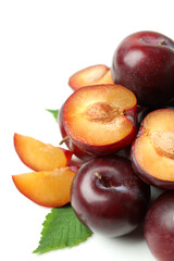 Tasty plums with leaves on white background