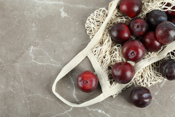 Concept of fruits with plums on gray textured table