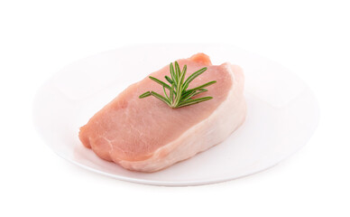 Raw pork in white plate on dark background