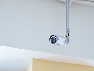 Small CCTV camera security mounted on the ceiling, Inside the building. - 460110972