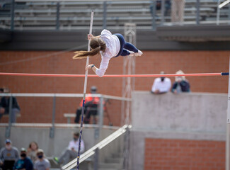High School girls competing in pole vault at a track and field meet