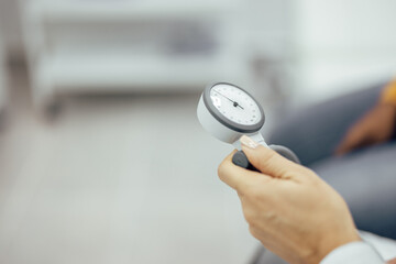 Doctor holding blood pressure manometer, close-up, copy space.