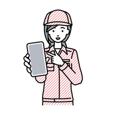 立ってスマートフォンを指差してこちらに向けて見せている作業員の女性