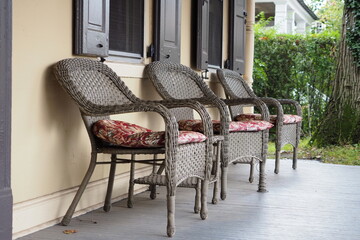 The3 wicker chairs are on the front porch. This is a rero style from any years ago.