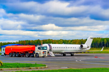White passenger plane at a gas station at an international airport. Ground maintenance. Vacation...