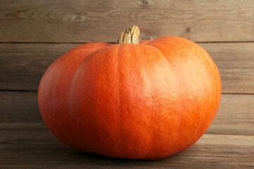 Fresh orange pumpkin on grey background. Autumn composition