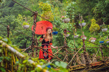 A female tourist dressed in the traditional dress of the inhabitants of the Vietnamese mountains,...