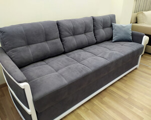 Beautiful stylish gray sofa.Sofas in the furniture showroom. Sale of sofas.