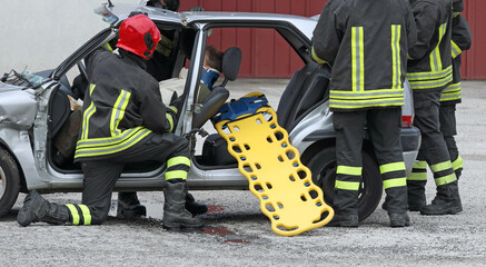 firefighters during rescue of the injured after the car accident with the stretcher to transport the injured