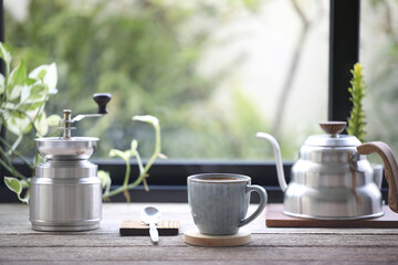 Blue coffee cup and stainless coffee grinder and drip pot