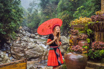 A female tourist dressed in the traditional dress of the inhabitants of the Vietnamese mountains,...