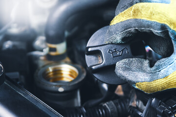 Mechanic hand open an oil filler cap of the engine car