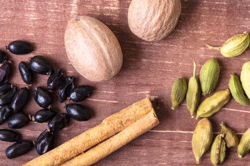Fototapeta na wymiar Cardamom, nutmeg, cinnamon and other aromatic spices lie on a wooden table