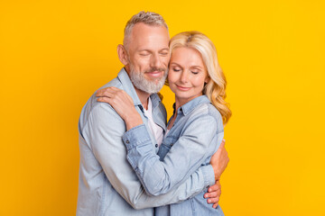 Photo of calm peaceful positive old couple hug embrace trust harmony enjoy isolated on yellow color background