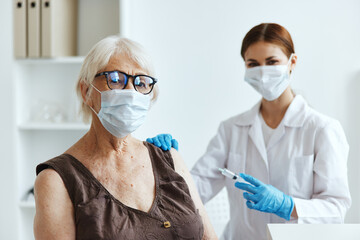 elderly woman wearing a medical mask next to the doctor immunity protection