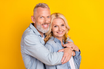 Photo of old happy positive married couple embrace good mood smile isolated on yellow color...