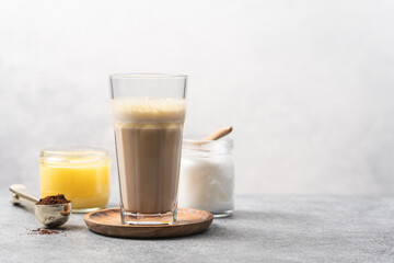 Glass Cup of bulletproof coffee and ingredients on white background. Ketogenic keto diet coffe blended with coconut oil and butter