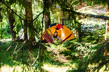 woman laying down in hammock in the forest tent on background