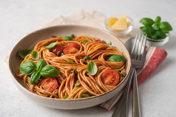 Whole wheat pasta with tomato sauce, fresh tomatoes and basil. Close-up view