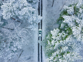 view of the white car from above in frozen winter forest