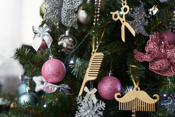 new year decoration on a Christmas tree in the form of scissors, a wooden comb and a wooden mustache. Christmas decorations for barbers and hairdressers. christmas decorations on the christmas tree