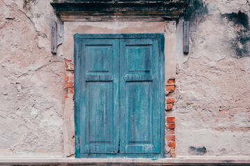 Old blue window on the antique wall.