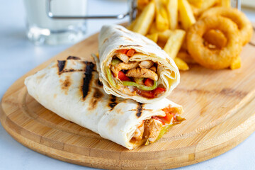 Chicken wrap on a white background. With french fries and onion rings