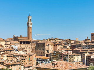 Obraz premium Cityscape of the old town of Siena a wonderful place in Tuscany, Italy with its old medieval little building and red roofs seen from Orto dei Tolomei